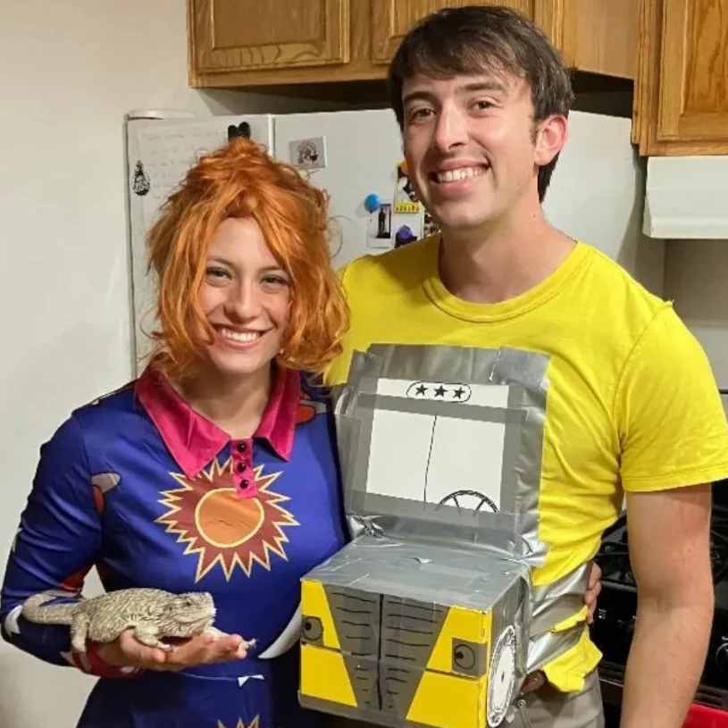 Halloween costume of myself as Miss Frizzle, with a Magic School Bus companion, and with my bearded dragon as Lizzy the lizard.